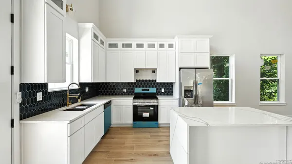 a kitchen with a stove a sink and a refrigerator
