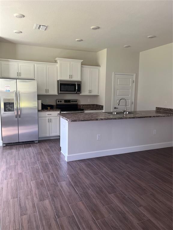 259 Bittern Loop Inverness, FL 34453 - Photo 3 of 18 a kitchen with stainless steel appliances granite countertop a stove a sink and a microwave