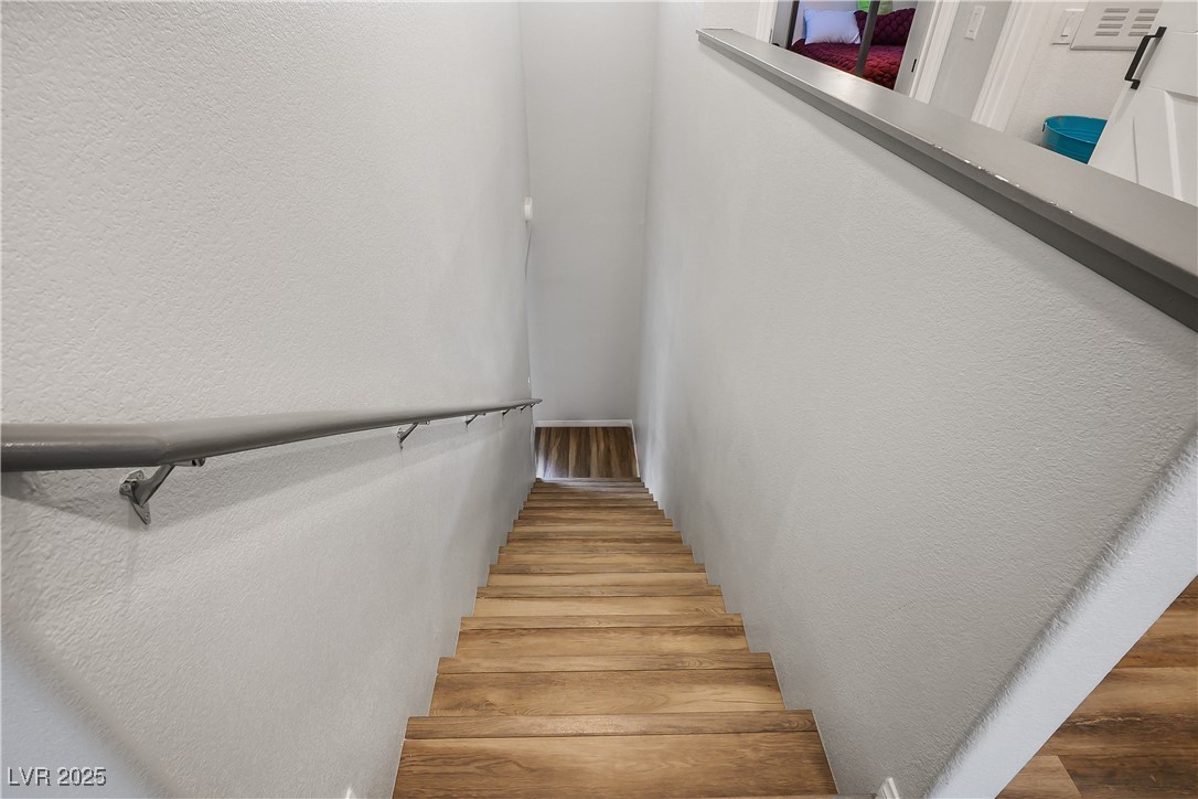 12236 Glass Desert Road, Unit 2 Las Vegas, NV 89183 - Photo 20 of 32 Stairway featuring a textured wall and wood finished floors