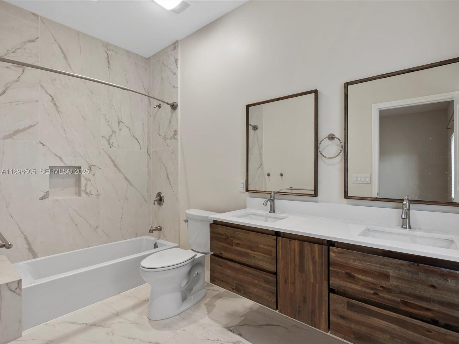 8501 Southwest 68th St Road Miami, FL 33143 - Photo 20 of 51 a bathroom with a double vanity sink toilet mirror and bathtub