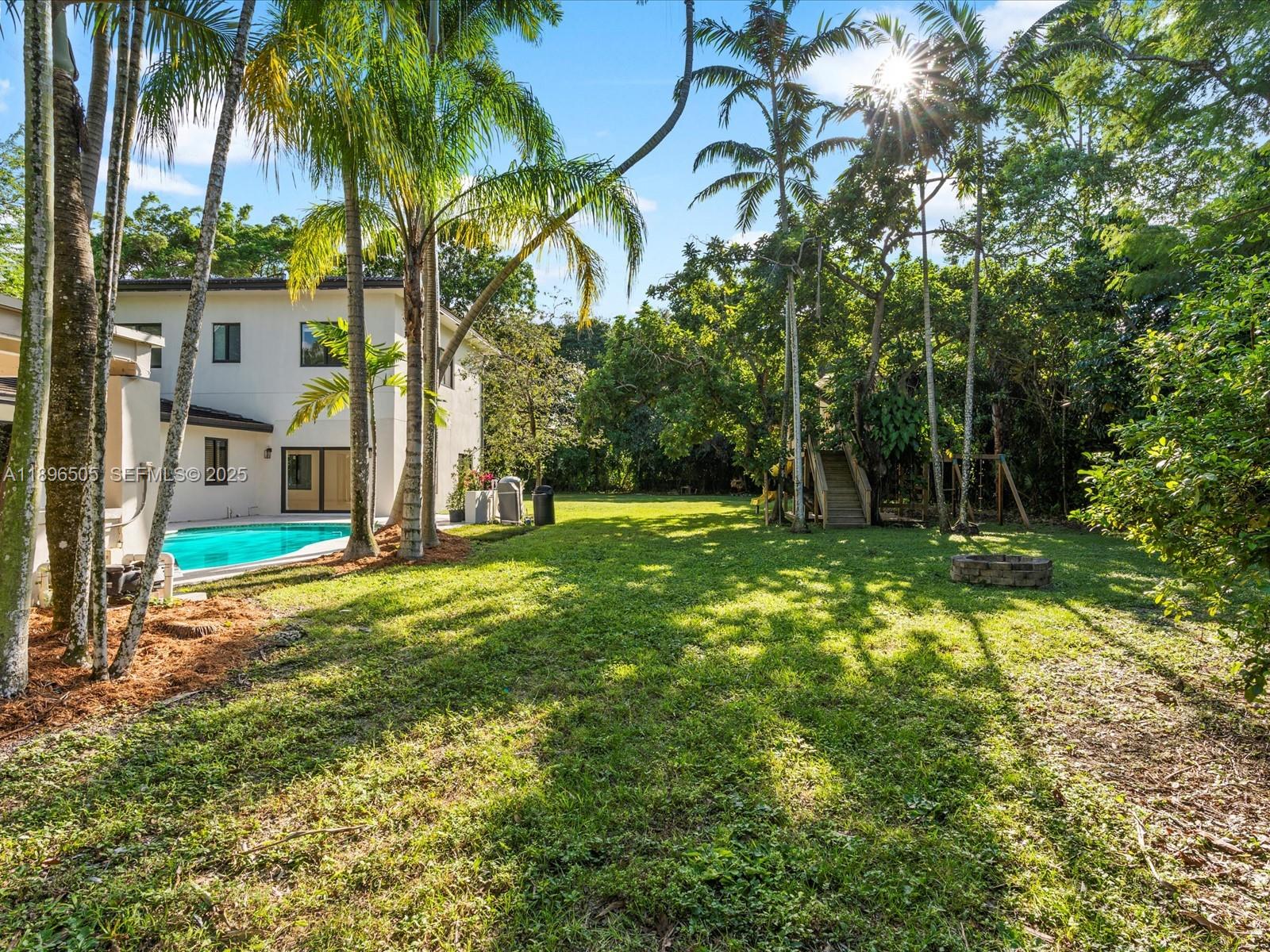 8501 Southwest 68th St Road Miami, FL 33143 - Photo 39 of 51 One-acre fenced yard with treehouse, jungle gym, covered outdoor kitchen, and deck — perfect for kids, pets, and entertaining, with space to add a tennis or pickleball court.
