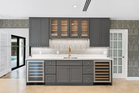 a kitchen with white cabinets and chairs