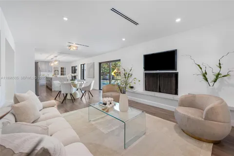 a kitchen with stainless steel appliances a refrigerator a stove a sink dishwasher and a dining table with wooden floor