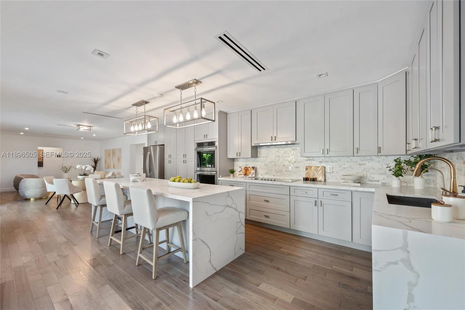 8501 Southwest 68th St Road Miami, FL 33143 - Photo 9 of 51 a kitchen with white cabinets and chairs