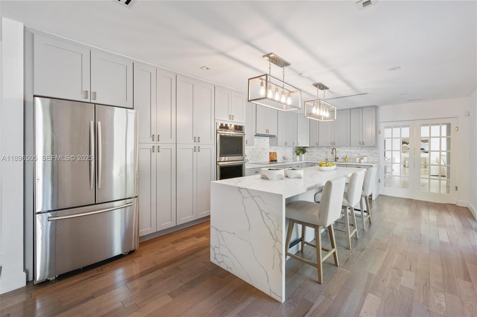 8501 Southwest 68th St Road Miami, FL 33143 - Photo 10 of 51 a kitchen with stainless steel appliances a refrigerator a stove a sink dishwasher and a dining table with wooden floor