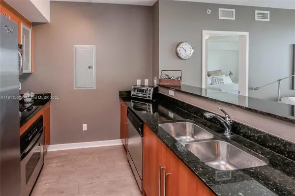 a kitchen with granite countertop a sink and a stove