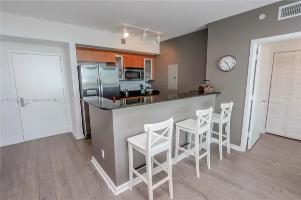 a kitchen with stainless steel appliances granite countertop a refrigerator a stove and a sink