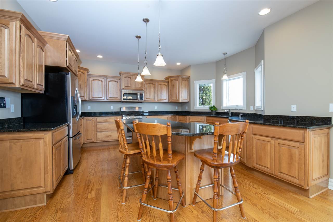 3097 North Marrill Road Byron, IL 61010 - Photo 11 of 40 a large kitchen with granite countertop lots of counter space white cabinets and stainless steel appliances