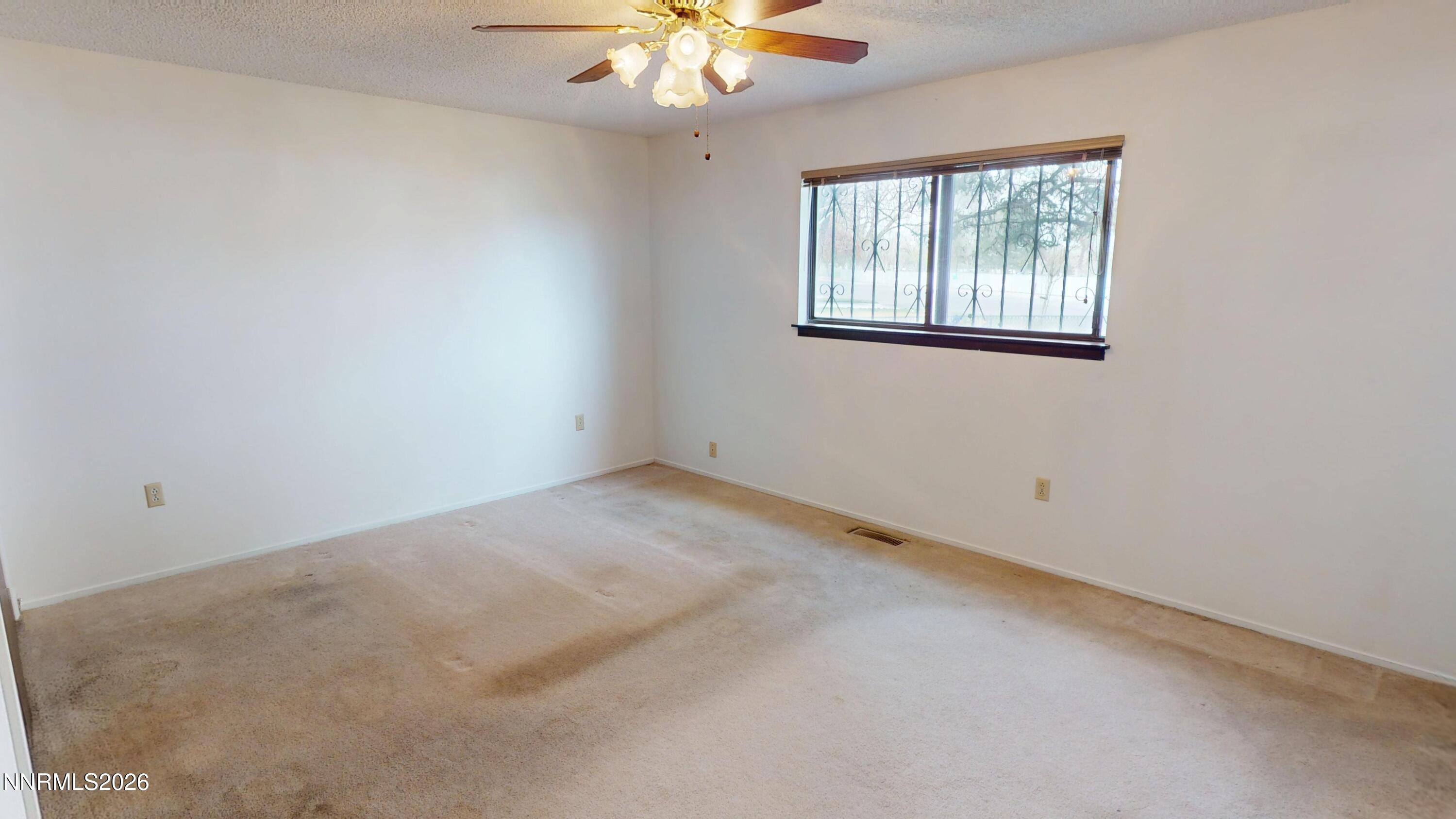 440 East Minor Street Winnemucca, NV 89445 - Photo 11 of 12 an empty room with windows and chandelier fan