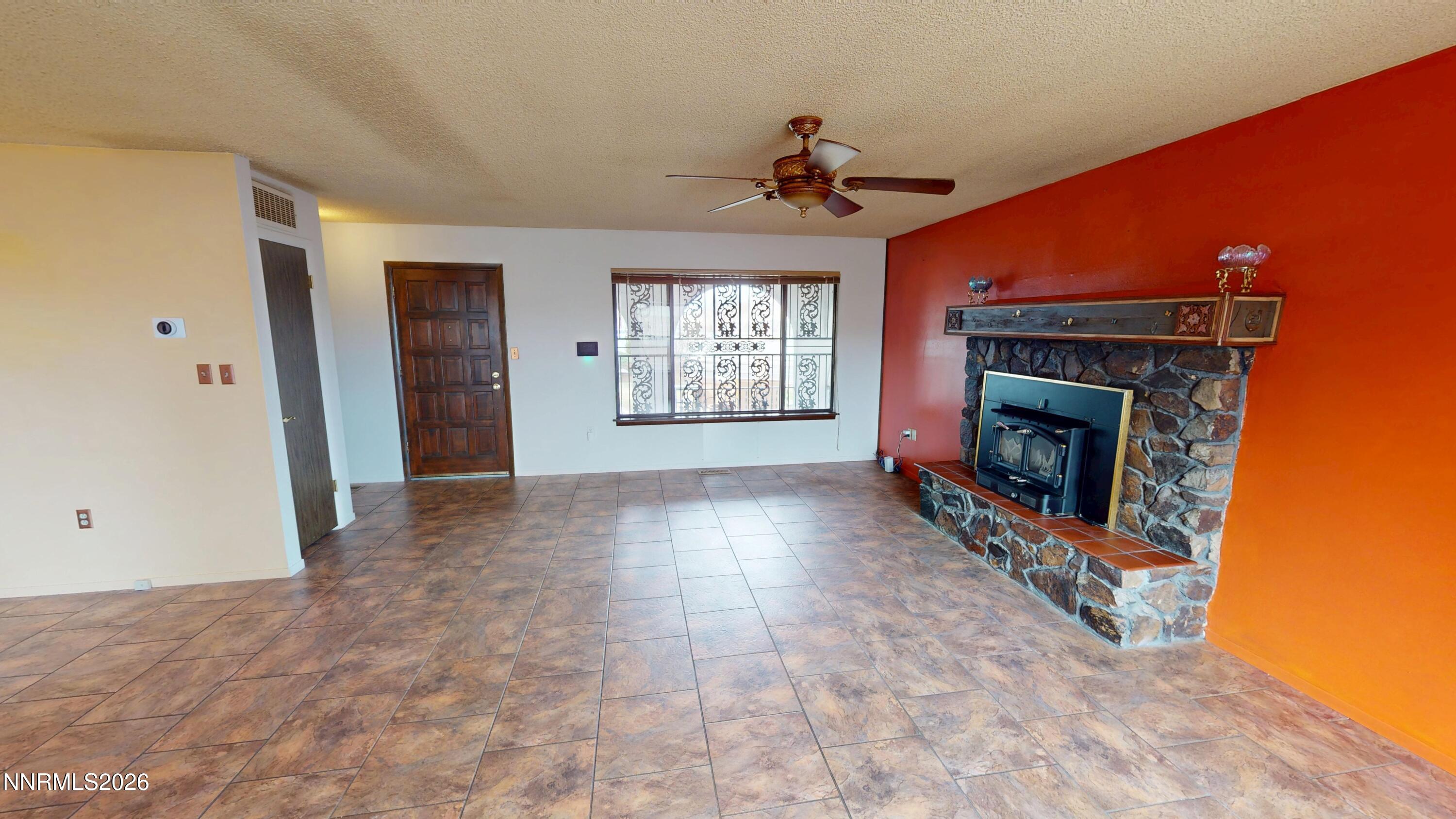 440 East Minor Street Winnemucca, NV 89445 - Photo 6 of 12 a view of an empty room with a fireplace and a window