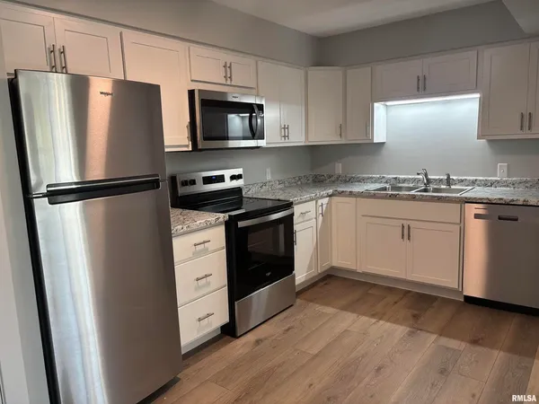 a kitchen with stainless steel appliances a refrigerator stove and microwave