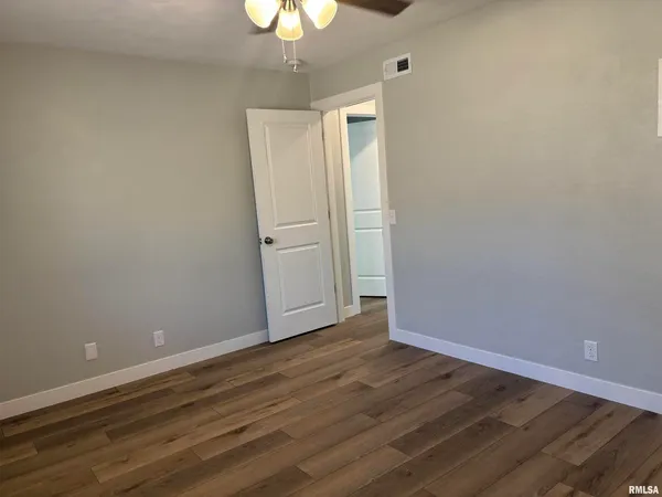 a view of an empty room with wooden floor