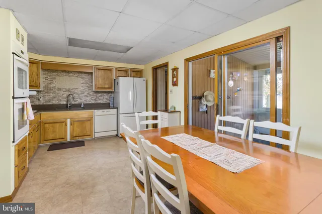 a kitchen with stainless steel appliances granite countertop a refrigerator a oven and white cabinets