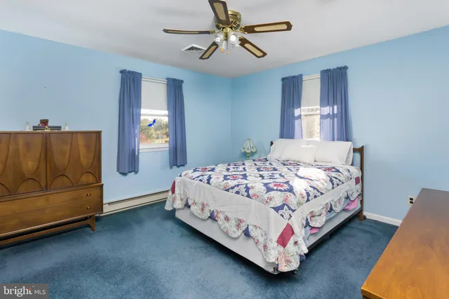 a bedroom with a bed and a large mirror on dresser
