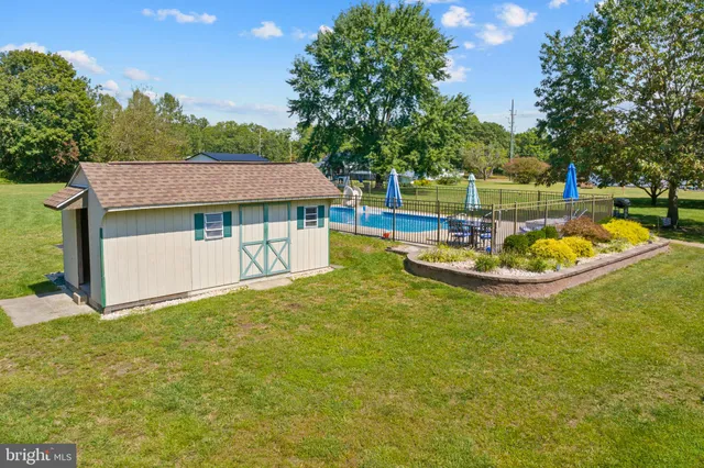 an aerial view of residential houses with outdoor space and trees