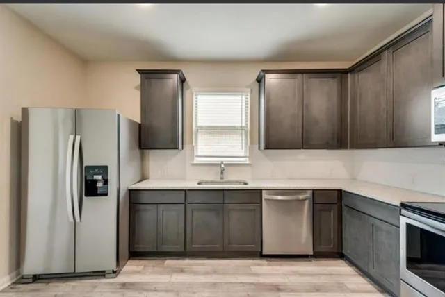 a kitchen with a sink and stainless steel appliances