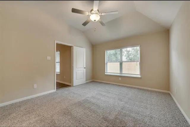 an empty room with a ceiling fan and a window