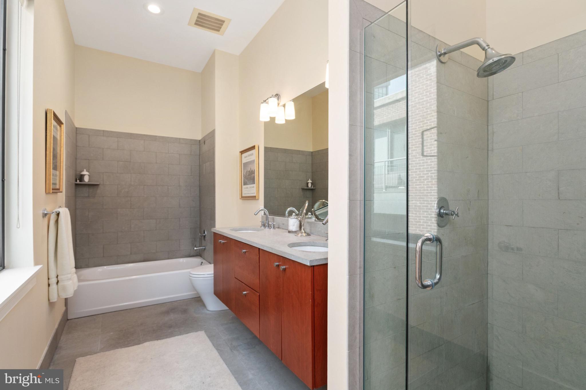 2516 Q Street Northwest, Unit C201 Washington, DC 20007 - Photo 12 of 20 a bathroom with a granite countertop shower a mirror and a sink