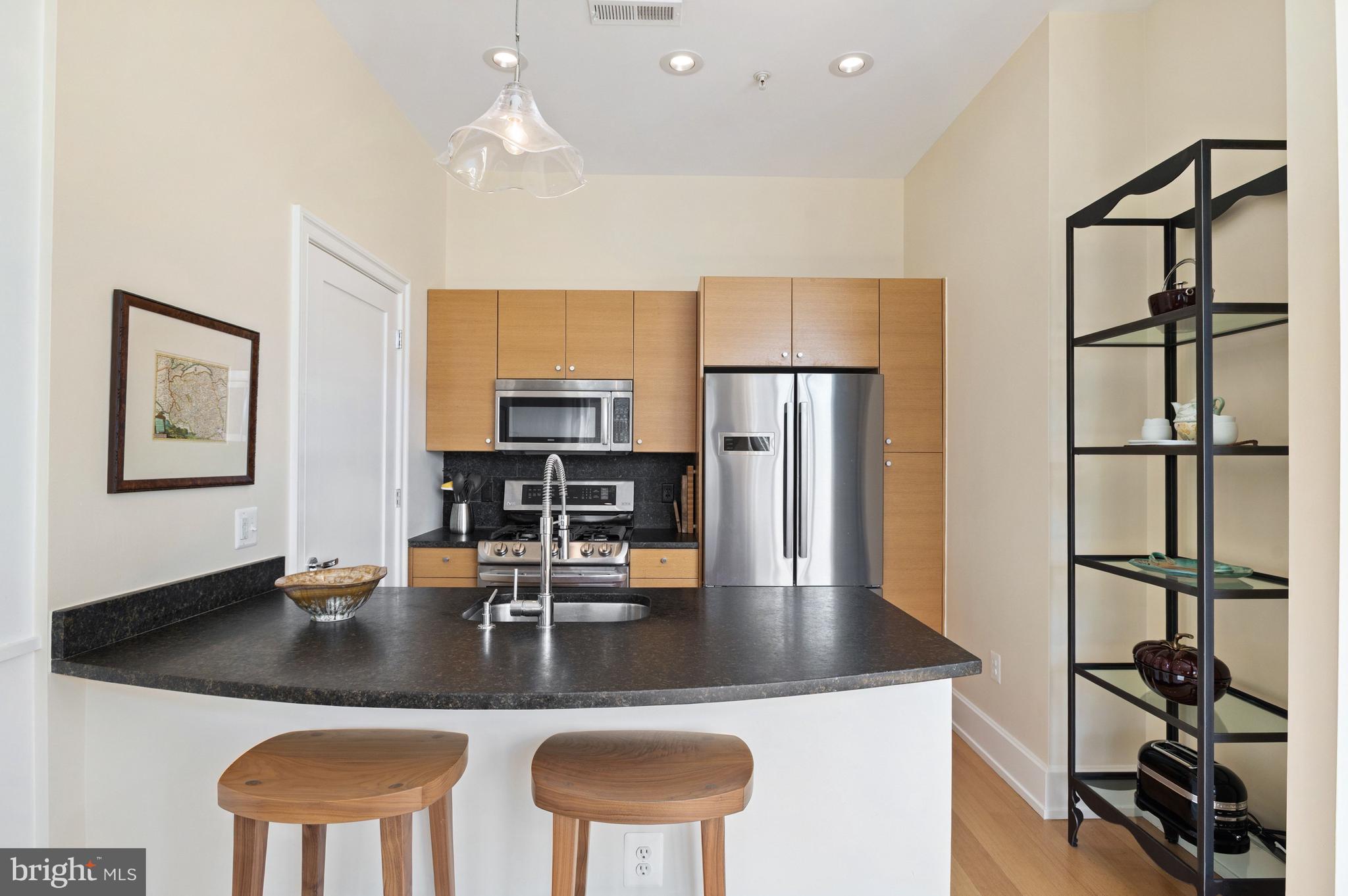 2516 Q Street Northwest, Unit C201 Washington, DC 20007 - Photo 6 of 20 a kitchen with stainless steel appliances granite countertop a sink and a refrigerator