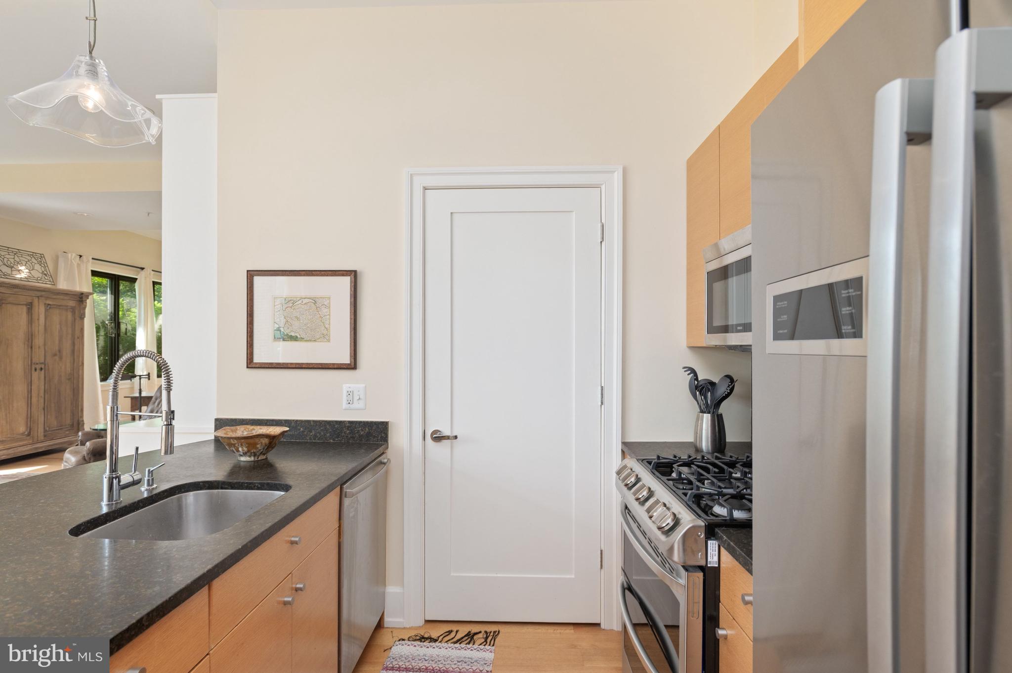 2516 Q Street Northwest, Unit C201 Washington, DC 20007 - Photo 8 of 20 a kitchen with granite countertop a sink stove and refrigerator