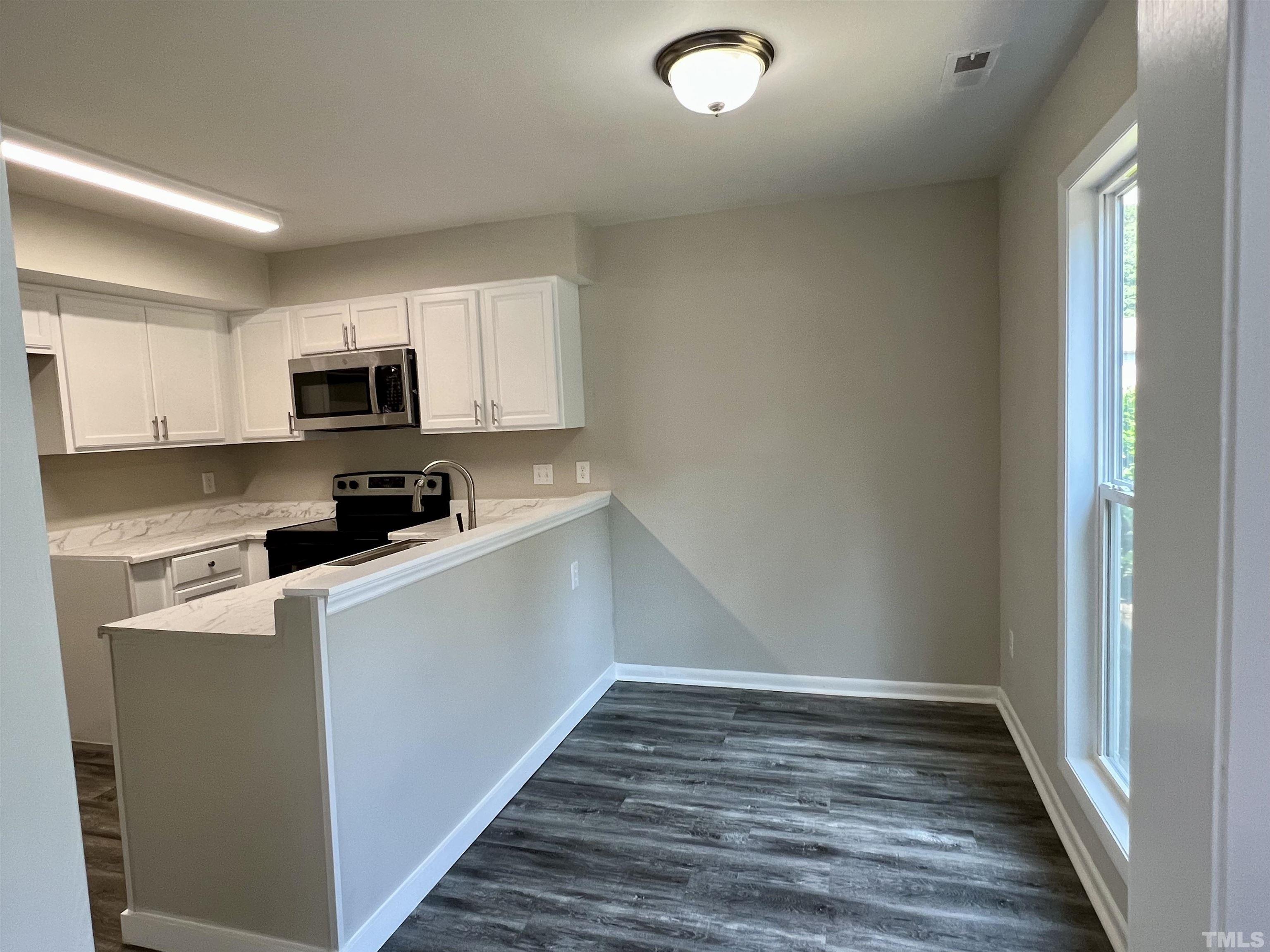 1304 Seaton Road Durham, NC 27713 - Photo 2 of 18 a kitchen with granite countertop a refrigerator and a stove top oven