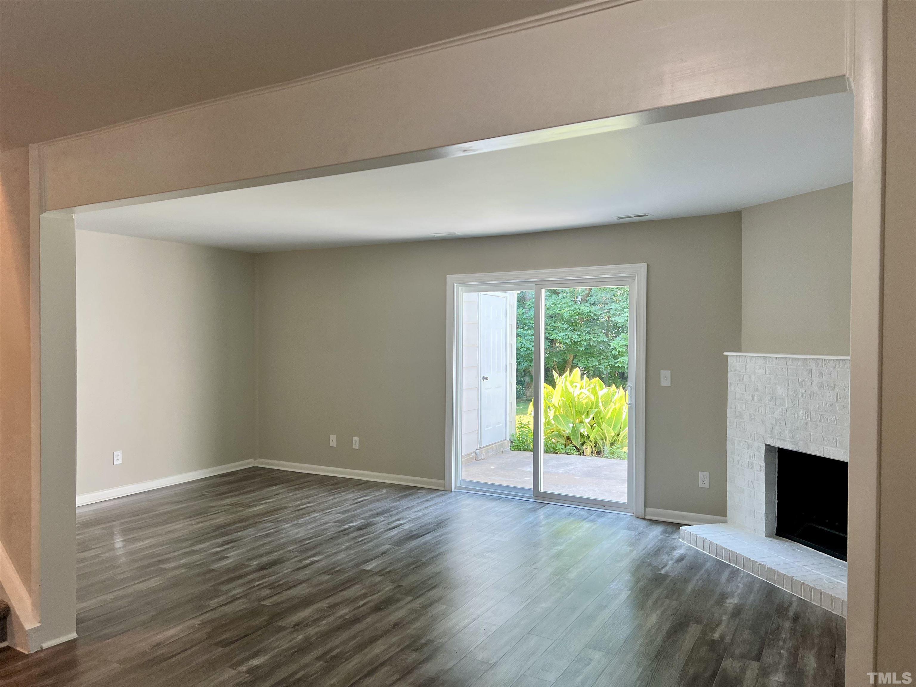 1304 Seaton Road Durham, NC 27713 - Photo 7 of 18 an empty room with wooden floor fireplace and windows