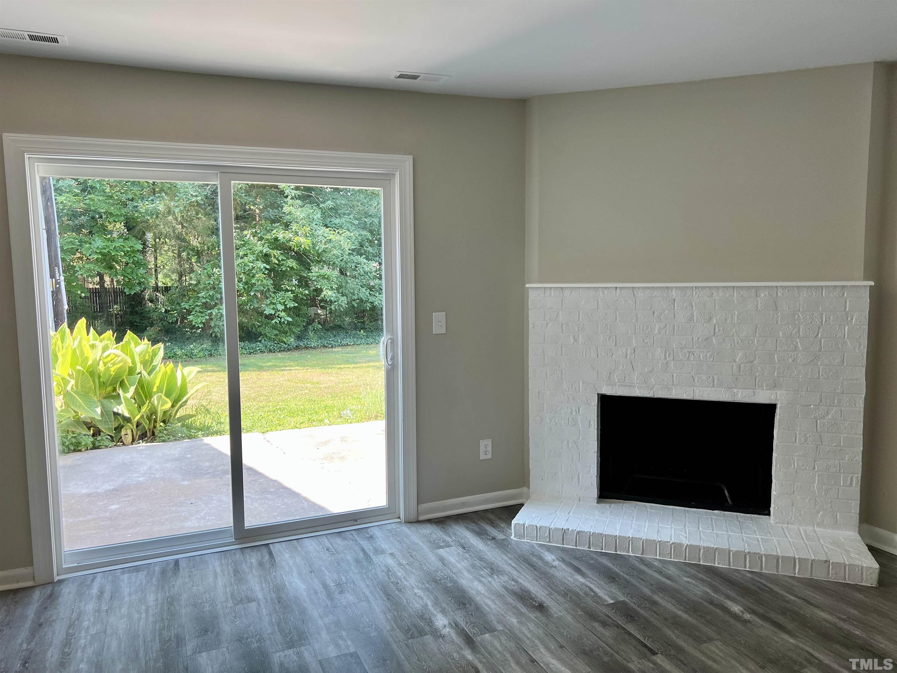 1304 Seaton Road Durham, NC 27713 - Photo 8 of 18 a view of an empty room with a fireplace and a window