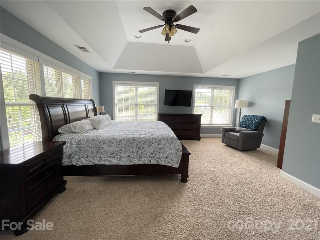 4004 Lamington Road Matthews, NC 28105 - Photo 12 of 31 a bedroom with a bed a couch and a flat tv screen on dresser