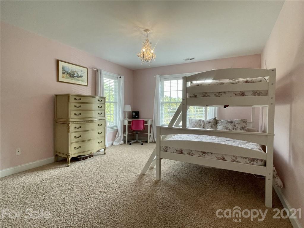 4004 Lamington Road Matthews, NC 28105 - Photo 17 of 31 a bedroom with a bed and a chandelier