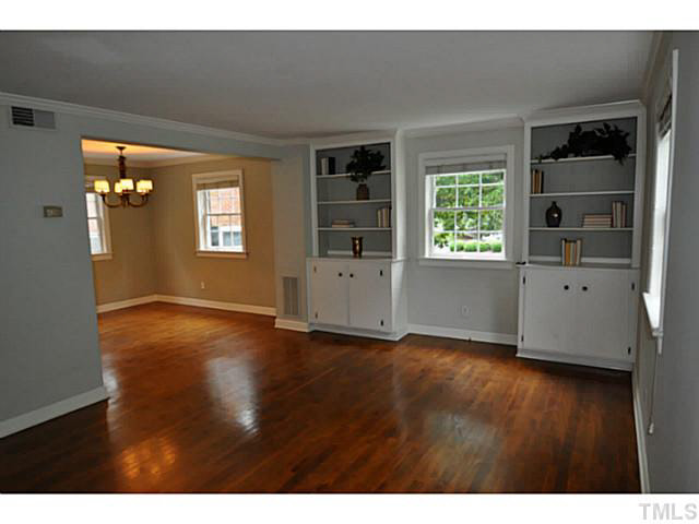 1000 Nichols Drive Raleigh, NC 27605 - Photo 2 of 21 Family room with hardwoods, built-in bookcases, new paint, and great light! Powder room is just off the family room, under the stairs.