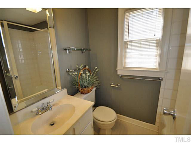 1000 Nichols Drive Raleigh, NC 27605 - Photo 9 of 21 2nd floor hall bath has updated lighting, tile surround on the tub, and new mirror.