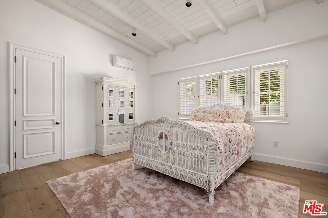 9609 Oak Pass Road Beverly Hills, CA 90210 - Photo 11 of 16 a bedroom with a bed rug and wooden floor