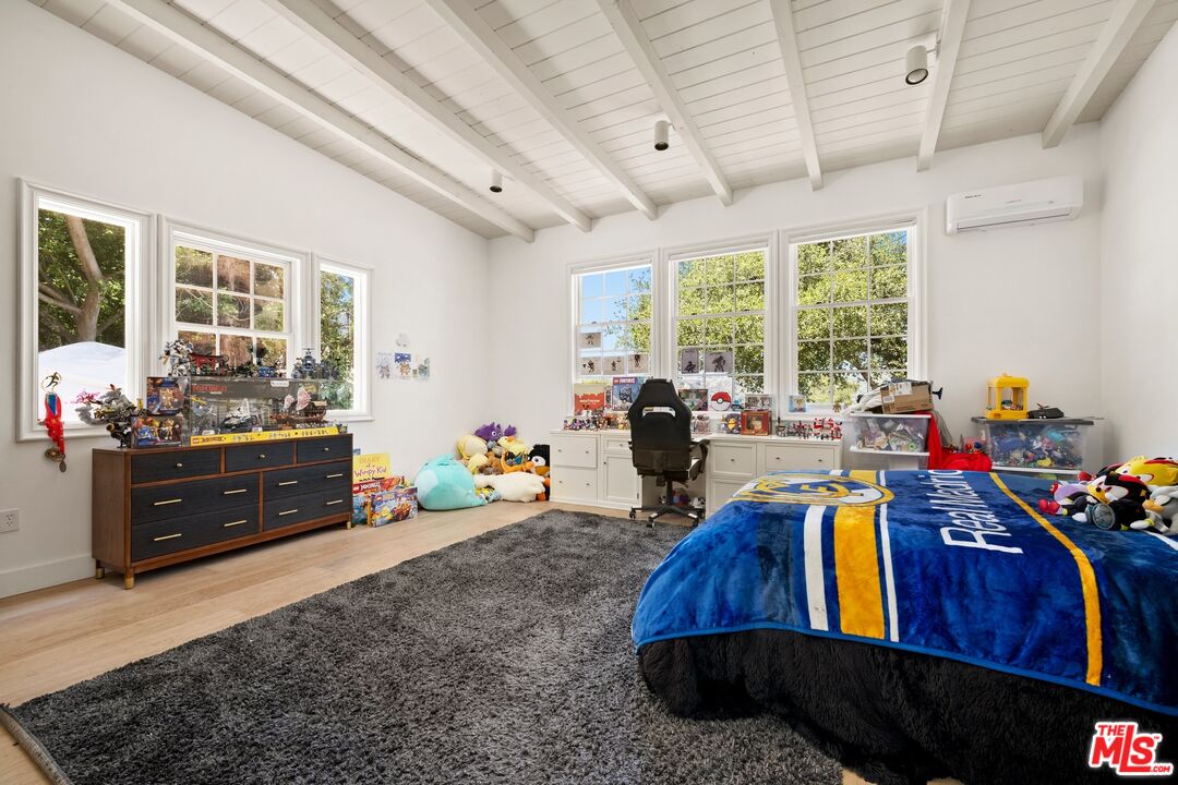 9609 Oak Pass Road Beverly Hills, CA 90210 - Photo 13 of 16 a bed room with furniture and a chandelier