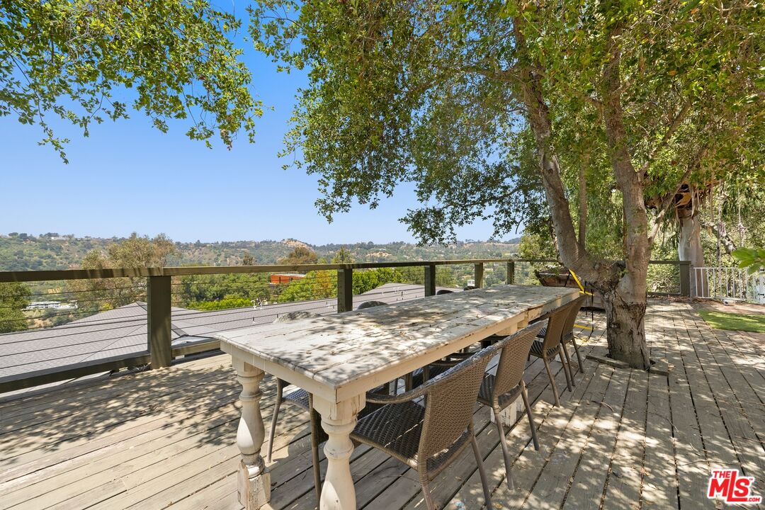 9609 Oak Pass Road Beverly Hills, CA 90210 - Photo 14 of 16 a view of a terrace with a table and chairs under an umbrella