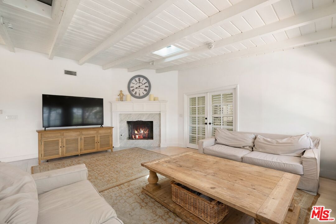 9609 Oak Pass Road Beverly Hills, CA 90210 - Photo 3 of 16 a living room with furniture and a flat screen tv