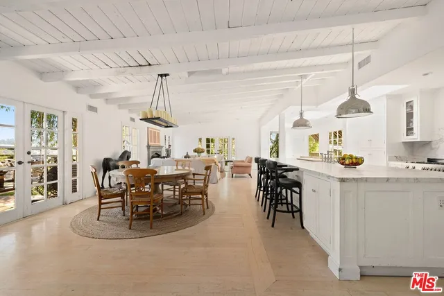 a view of a dining room and livingroom with furniture wooden floor a chandelier