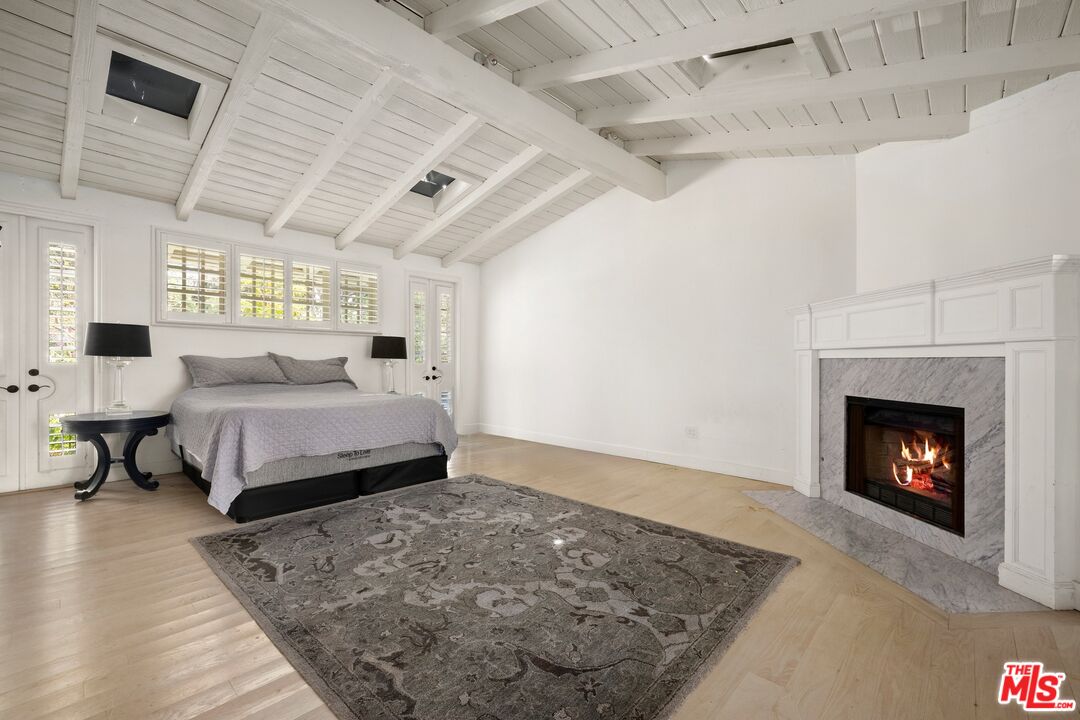 9609 Oak Pass Road Beverly Hills, CA 90210 - Photo 8 of 16 a bedroom with a bed and a fireplace