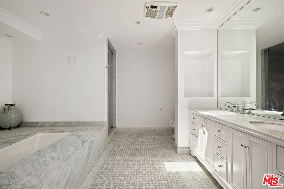 9609 Oak Pass Road Beverly Hills, CA 90210 - Photo 9 of 16 a spacious bathroom with a double vanity sink and mirror