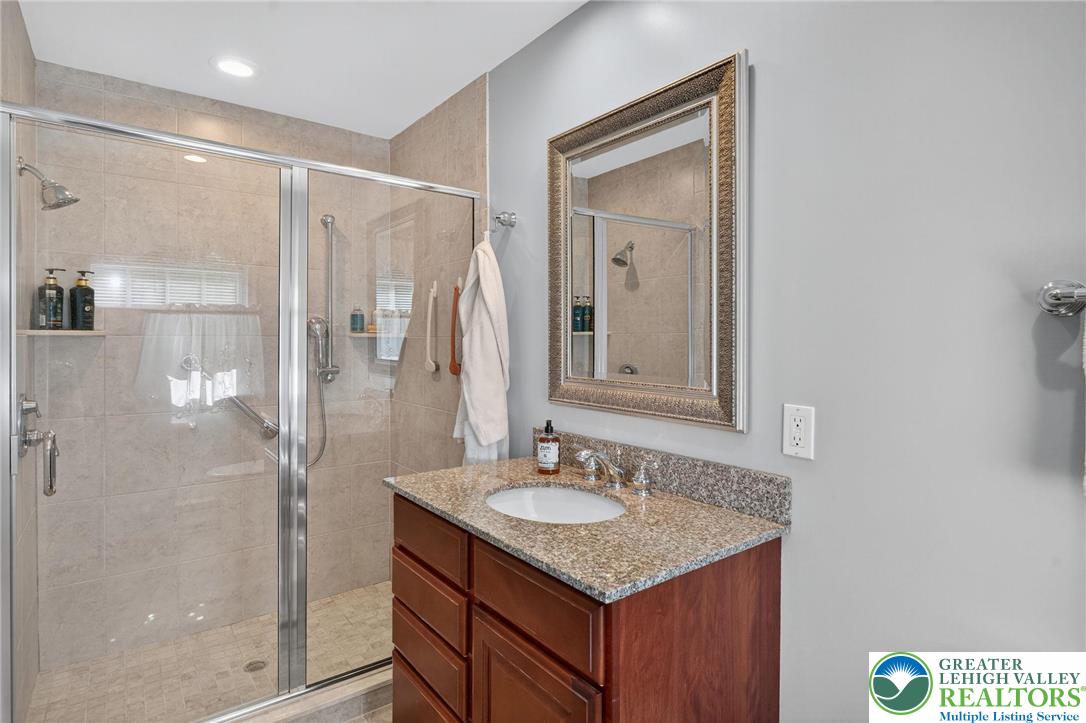 1830 Sherwood Road Allentown, PA 18103 - Photo 37 of 68 a bathroom with a shower sink vanity and mirror