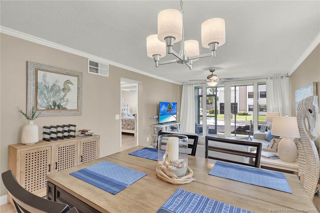 1950 Southwest Palm City Road, Unit 9108 Stuart, FL 34994 - Photo 11 of 37 a living room with furniture a rug and a chandelier