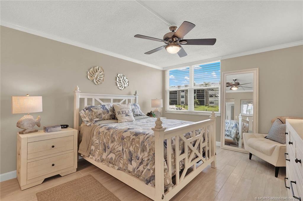 1950 Southwest Palm City Road, Unit 9108 Stuart, FL 34994 - Photo 20 of 37 a bedroom with a bed and a chandelier