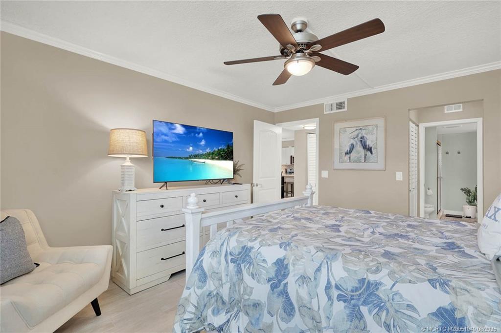1950 Southwest Palm City Road, Unit 9108 Stuart, FL 34994 - Photo 22 of 37 a bedroom with a bed window and a flat screen tv
