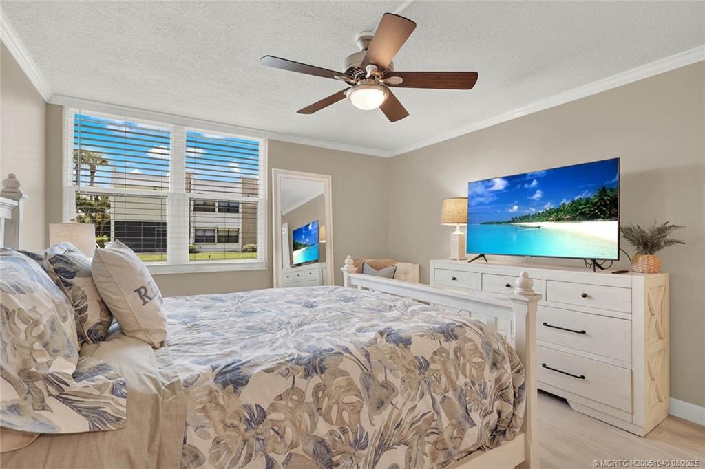 1950 Southwest Palm City Road, Unit 9108 Stuart, FL 34994 - Photo 23 of 37 a bedroom with a bed and a flat screen tv