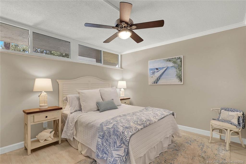 1950 Southwest Palm City Road, Unit 9108 Stuart, FL 34994 - Photo 27 of 37 a bedroom with a bed and a chandelier