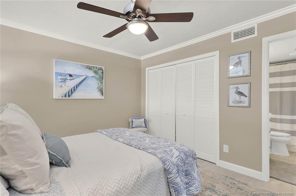 1950 Southwest Palm City Road, Unit 9108 Stuart, FL 34994 - Photo 28 of 37 a bedroom with a large bed and a chandelier