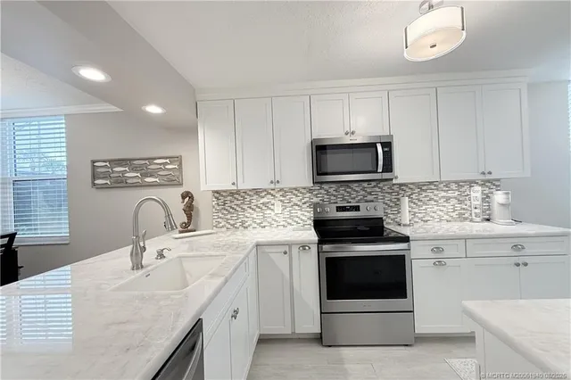 a kitchen with a sink stove and microwave