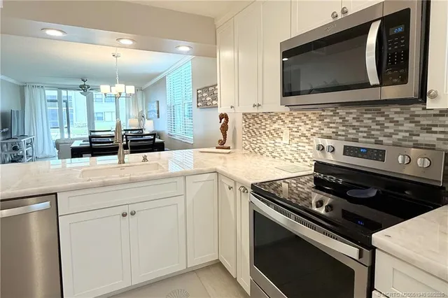 a kitchen with white cabinets and sink