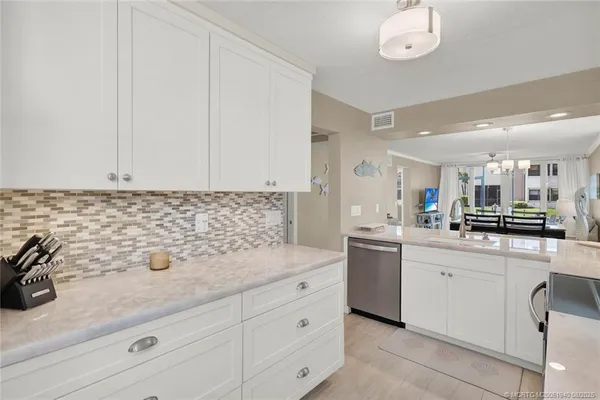 a kitchen with granite countertop white cabinets and stainless steel appliances