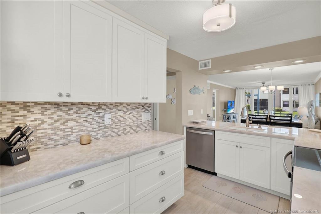 1950 Southwest Palm City Road, Unit 9108 Stuart, FL 34994 - Photo 8 of 37 a kitchen with white cabinets and sink