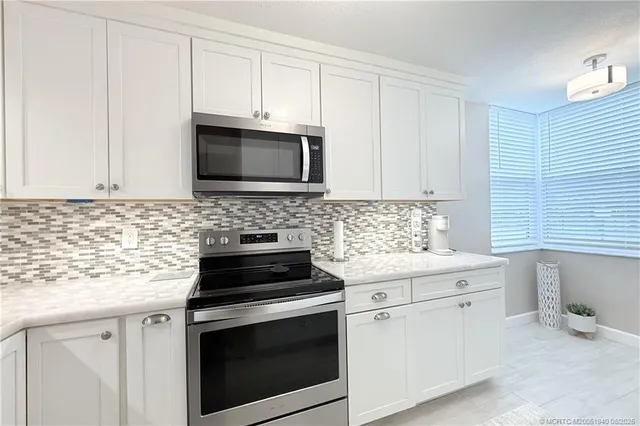 a kitchen with granite countertop a sink stove and cabinets